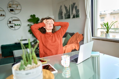 Cliquez sur le bureau pour explorer les ressources en bureautique. Une femme détendue à son bureau, illustrant une bureautique optimisée.