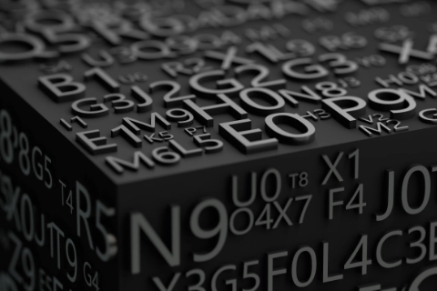 Un cube noir orné de lettres et de chiffres en relief, illustrant la typographie.