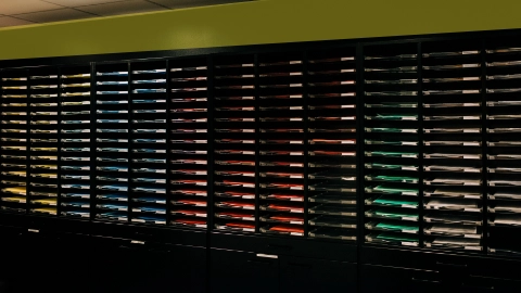 Salle d’archivage contenant des dossiers organisés par couleur, illustrant l’organisation de votre historique par type de service commandé.